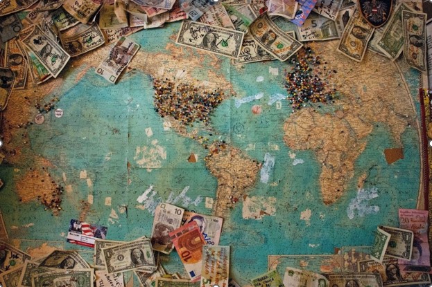 A global map with money pinned to it, representing Elijah Norton’s international company